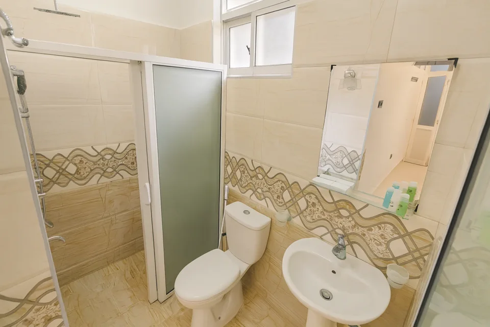 Katunayaka ground-floor bathroom with a glass shower enclosure, toilet and basin