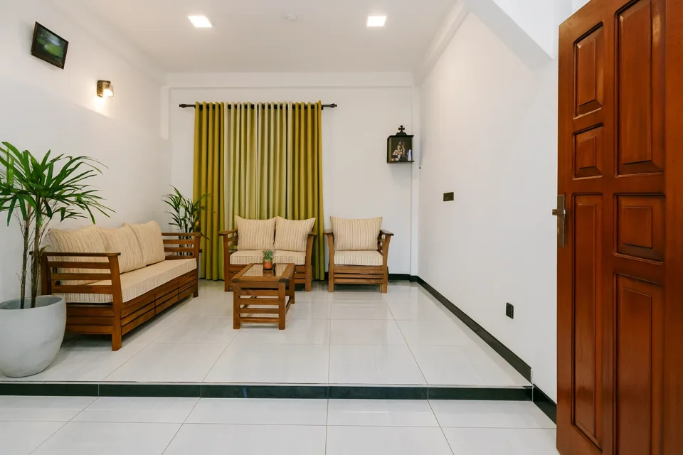 Ground-floor apartment sitting area with wooden seating and yellow curtains
