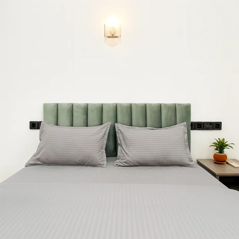 First-floor bed with grey linen and a green headboard
