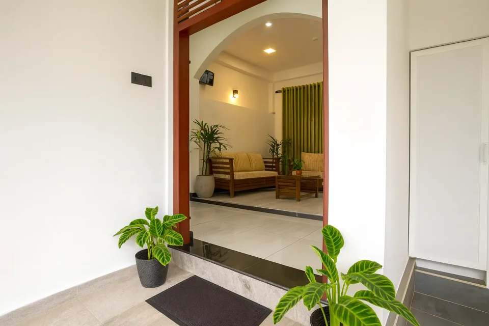 Apartment entrance with potted plants and a view into the sitting area