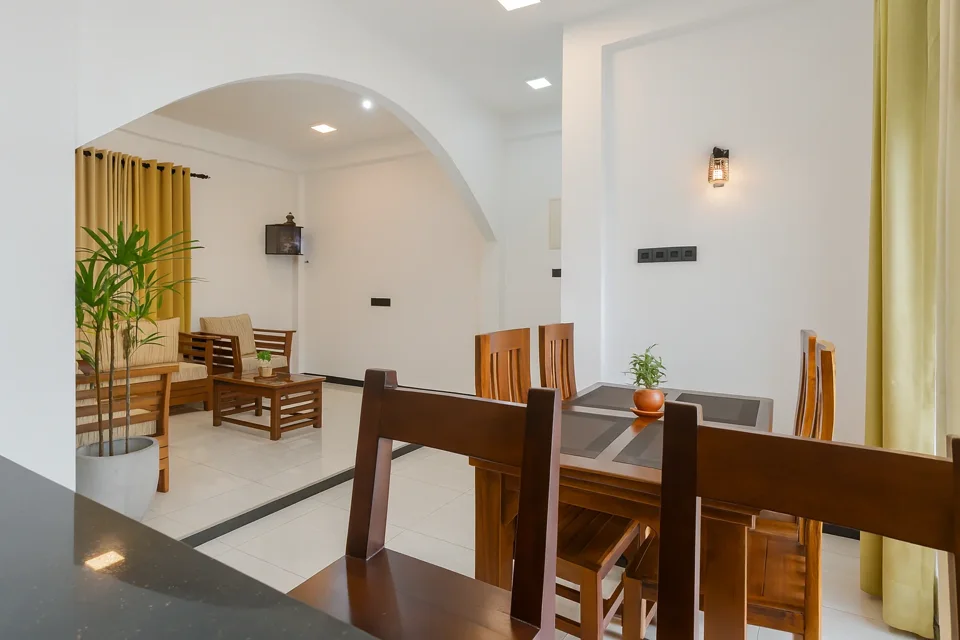 Wooden dining table with an arched opening toward the Katunayaka sitting area
