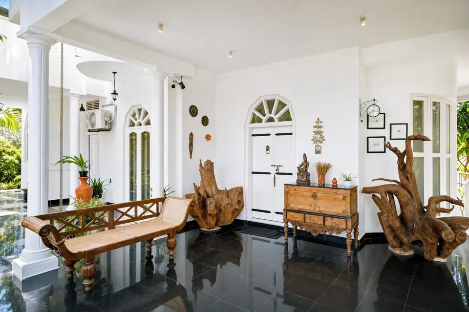 Open sitting area with carved wooden chairs at Skyport Villa Negombo