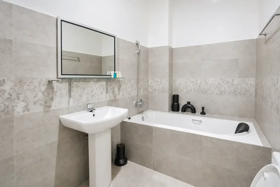 Negombo ground-floor bathroom with a bathtub, basin and large mirror