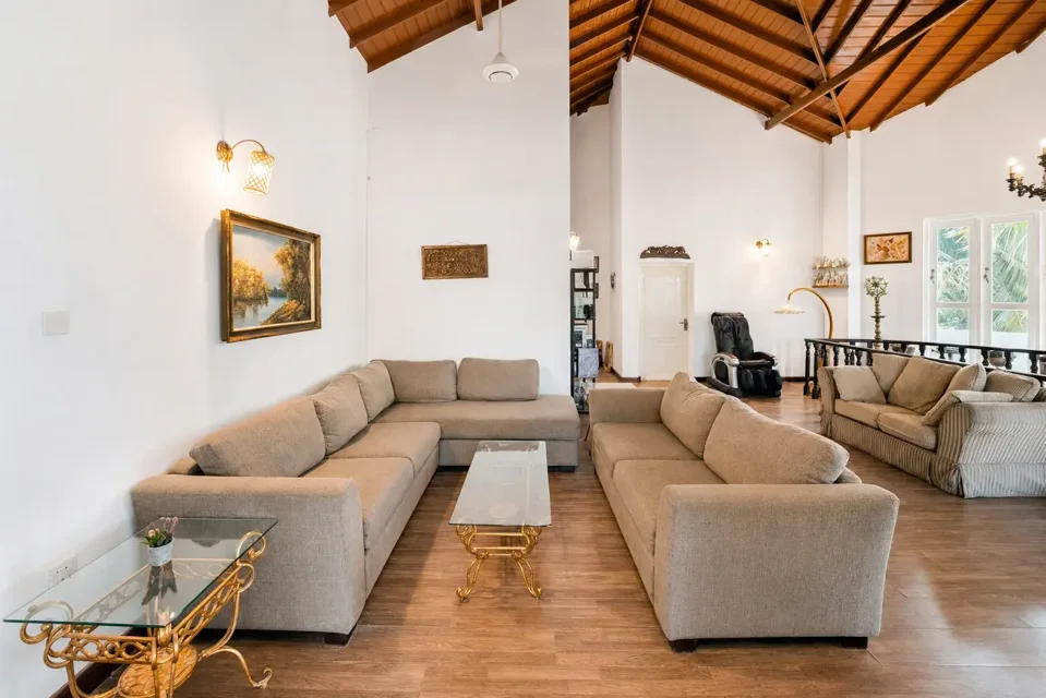 Upstairs sitting area with neutral sofas and a timber ceiling